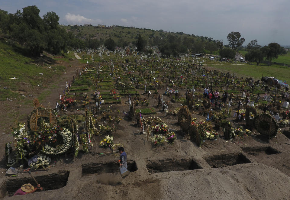 Cemetery workers dig fresh graves in a section of the Valle de Chalco Municipal Cemetery which opened early in the coronavirus pandemic to accommodate the surge in deaths, in Valle de Chalco on the outskirts of Mexico City, Thursday, Sept. 24, 2020.(AP Photo/Rebecca Blackwell)