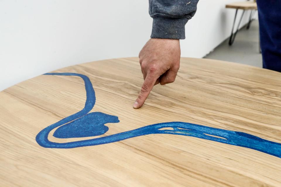 Brian Presnell, owner of Indy Urban Hardwood, points to the spot in the Virginia B. Fairbanks Art & Nature Park at the Indianapolis Museum of Art, where wood was harvested to make the river table shown here, on Tuesday, March 8, 2022, at Indy Urban Hardwood in Indianapolis. The table depicts the white river and lake located behind the Museum. Wood harvested from the IMA will be used to make an array of furniture and other wooden items for the Newfields campus. 