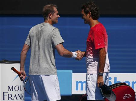 Roger Federer of Switzerland shakes hands with coach Stefan Edberg of Sweden at a practice session at the Australian Open 2014 tennis tournament in Melbourne January 14, 2014. Edberg believes his return to the Tour as a coach of Roger Federer can help the Swiss add to his record tally of 17 grand slam titles. REUTERS/Petar Kujundzic