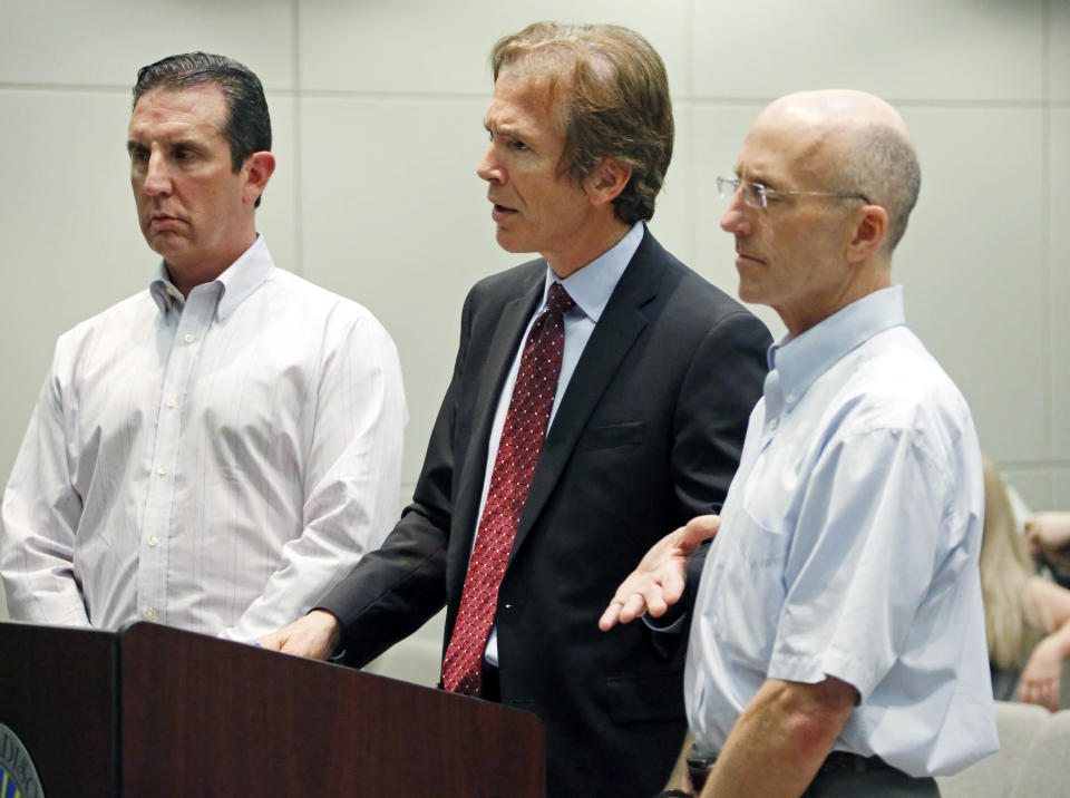 FILE - In this Thursday, May 22, 2014 file photo, Mark Mayfield, a member of the board of the Central Mississippi Tea Party, right, listens as his attorney Merrida Coxwell, center, responds to questions from city judge Dale Danks in Madison, Miss. U.S. District Judge Carlton Reeves ruled Wednesday, May 19, 2021, that relatives of late Ridgeland lawyer Mark Mayfield had not proven that the city of Madison had improperly retaliated against Mayfield for constitutionally protected speech or political activity. (AP Photo/Rogelio V. Solis, File)