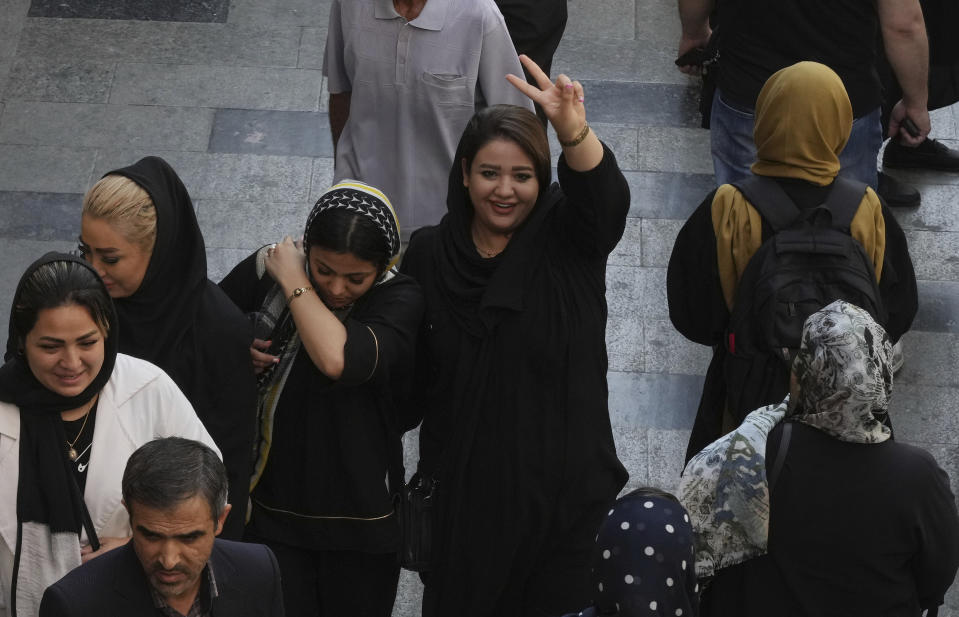 A woman flashes a victory sign as she walks around in the old main bazaar of Tehran, Iran, Saturday, Oct. 1, 2022. Thousands of Iranians have taken to the streets over the last two weeks to protest the death of Mahsa Amini, a 22-year-old woman who had been detained by the morality police in the capital of Tehran for allegedly wearing her mandatory Islamic veil too loosely. (AP Photo/Vahid Salemi)