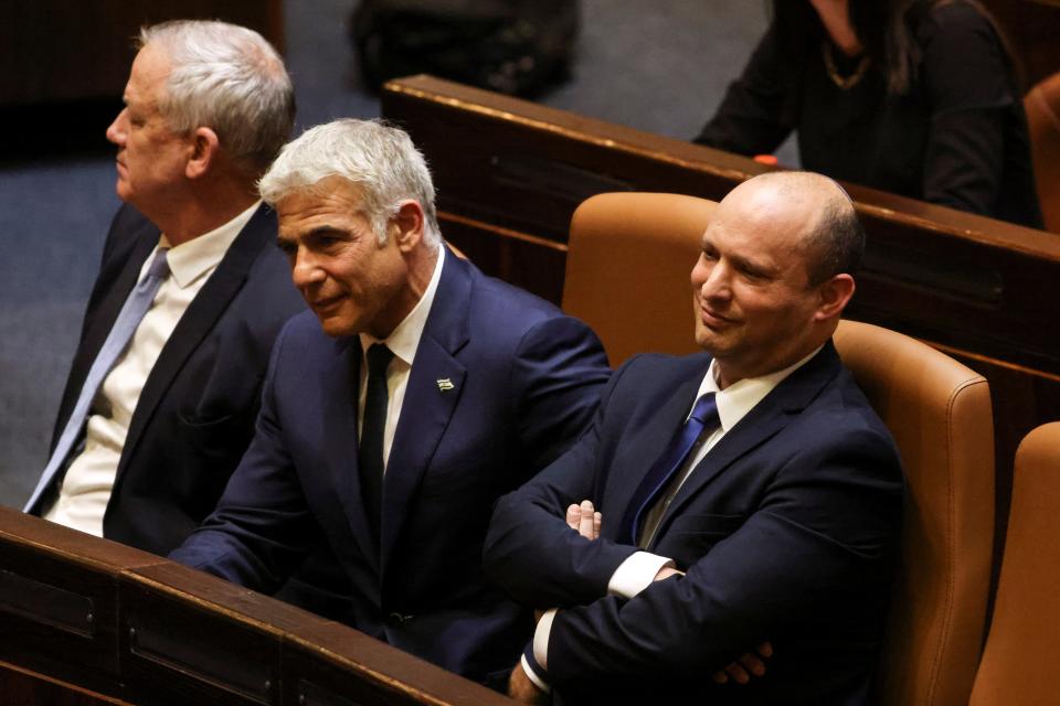 Israeli defence minister Benny Gantz, foreign minister Yair Lapid and new PM Naftali Bennett sit side by side (left to right) in parliament on Sunday (Reuters)