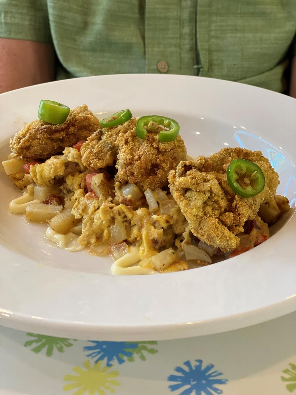 Fried Oyster Scramble "Hangtown" at Big Bad Breakfast. Eggs are scrambled with bacon, potatoes and tomatoes and are topped with fried Gulf oysters.