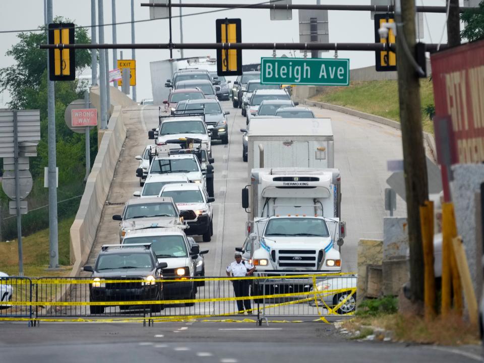 An officer directs traffic detoured from the Interstate 95 collapse.