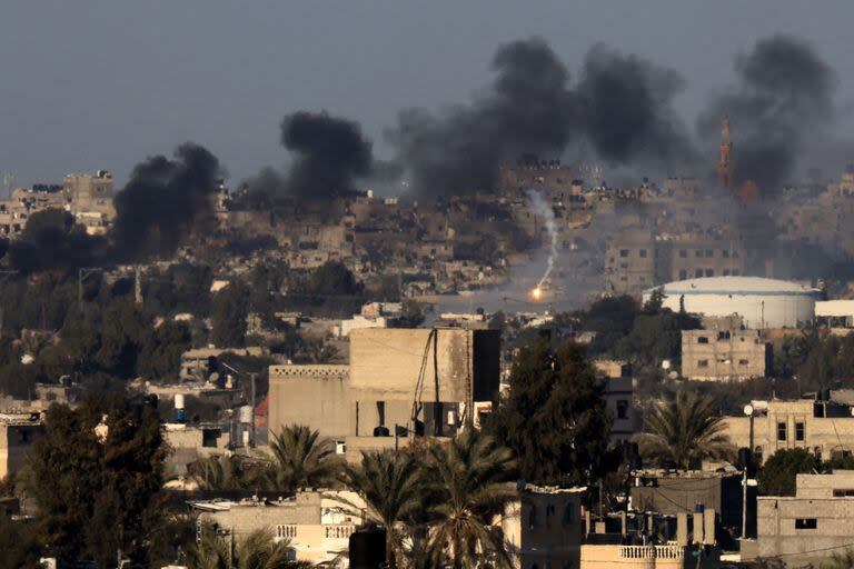 Esta fotografía tomada el 15 de enero de 2024 desde Rafah muestra una bengala y humo ondeando sobre Khan Yunis, en el sur de la Franja de Gaza.