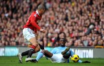 Manchester United's Chris Smalling (left) in action with Manchester City's Gnegneri Toure Yaya