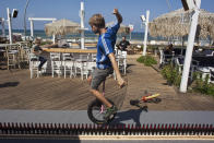 25-year-old German Lutz Eichholz rides his unicycle along upright beer bottles in Tel Aviv on September 26, 2011, during his attempt to break the world record. Eichholz on Monday set a new Guinness world record by riding his unicycle over a 8.93-metre-long row of 127 beer bottles. According to organisers, the previous record was 7.99 metres. REUTERS/Nir Elias