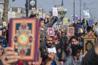 Followers of the Shiite cleric Muqtada al-Sadr raise the Quran, the Muslim holy book, in response to the burning of a copy of the Quran in Sweden, during open-air Friday prayers in Baghdad, Iraq, Friday, Jan. 27, 2023. (AP Photo/Hadi Mizban)