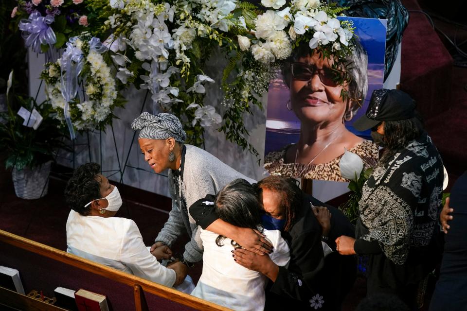 Mourners comfort Angela Crawley, seated at bottom left, and Robin Harris, daughters of Ruth Whitfield, a victim of the Buffalo supermarket shooting, before a memorial service at Mt. Olive Baptist Church with Vice President Kamala Harris in attendance, Saturday, May 28, 2022, in Buffalo, N.Y. (AP Photo/Patrick Semansky)