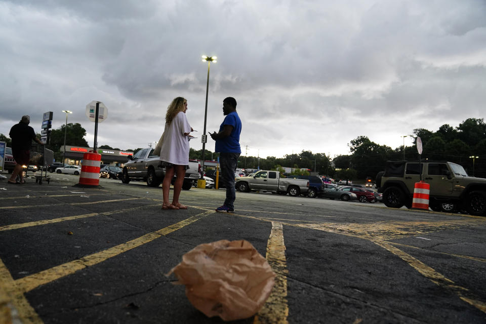 FILE - Canvasser Sienna Giraldi, 26, left, talks to an Atlanta resident, right, Thursday, July 20, 2023, in Atlanta. Activists with the Stop Cop City Vote Coalition collected signatures to force a referendum allowing voters to decide the fate of a proposed police and firefighter training center. But an analysis of petition entries by four news organizations finds it’s unclear whether petitioners have enough valid entries to force the citywide vote, with nearly half the entries unable to be matched to eligible registered Atlanta voters. (AP Photo/Brynn Anderson, file)