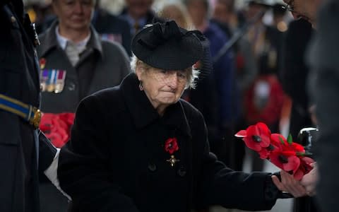 Francesca Shaw, from Leeds, England, prepares to lay a poppy wreath during an Armistice ceremony at the Menin Gate - Credit: AP Photo/Virginia Mayo