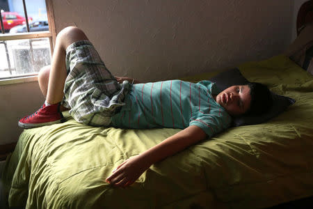 Anthony, 17, who suffers from tuberous sclerosis and Lennox-Gastaut syndrome, lies on a bed at his house in Lima, Peru, February 23, 2017. REUTERS/Guadalupe Pardo