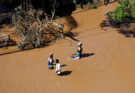 Locals stop to chat in a flooded area after Cyclone Idai in Buzi district outside Beira, Mozambique, March 22, 2019. REUTERS/Siphiwe Sibeko