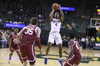 Baylor guard LJ Cryer (4) pulls up for a score between Oklahoma forward Tanner Groves (35) and guard Joe Bamisile (4) during the first half of an NCAA college basketball game Wednesday, Feb. 8, 2023, in Waco, Texas. (AP Photo/Rod Aydelotte)