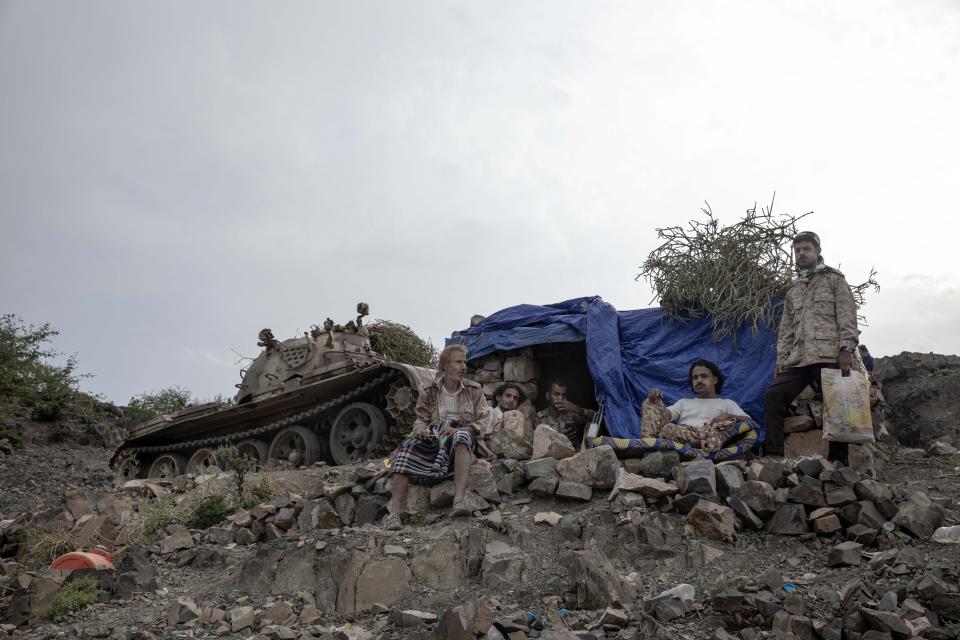 In this Monday, Aug. 5, 2019 photo, fighters from a militia known as the Security Belt, that is funded and armed by the United Arab Emirates, take a break to chew Qat, a fresh leaf chewed for its stimulating effects, at the Gabhet Hajr frontline with Houthi rebels, in Yemen's Dhale province. Yemen’s civil war has been deadlocked for months, with neither side making major gains. At one of the most active front lines, militiamen backed by the Saudi-led coalition are dug in, exchanging shelling every night with Iranian-allied Houthi rebels only a few hundred meters away. (AP Photo/Nariman El-Mofty)