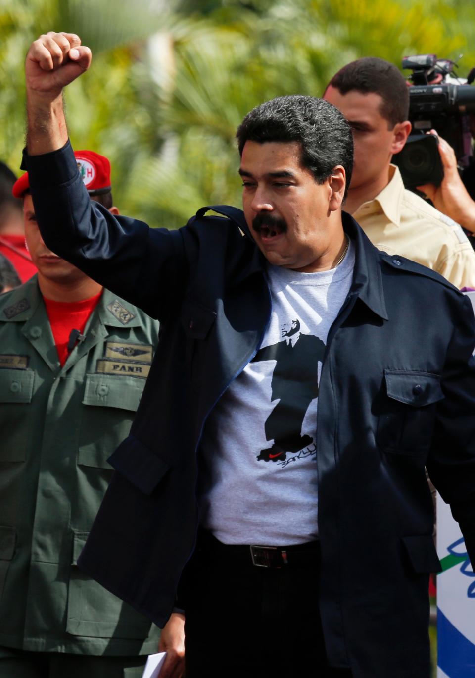 Venezuela's President Nicolas Maduro greets supporters upon his arrival for a rally outside Miraflores Presidential Palace in Caracas, Venezuela, Saturday, Feb. 22, 2014. Venezuelans on both sides of the nation's political divide took to the streets on Saturday after nearly two weeks of mass protests that have Maduro scrambling to reassert his leadership of his bitterly divided country. (AP Photo/Fernando Llano)