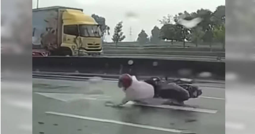 男子在雨天摔車，差點遭大貨車撞上。（圖／翻攝自「爆料公社二社」臉書）