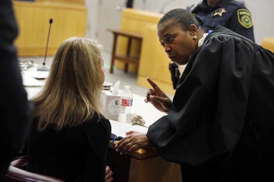 Former Dallas Police Officer Amber Guyger, left, listens to words of advice and encouragement from State District Judge Tammy Kemp after the judge had given her a Bible and before Guyger left for jail, Wednesday, Oct. 2, 2019, in Dallas. Guyger, who said she mistook neighbor Botham Jean's apartment for her own and fatally shot him in his living room, was sentenced to a decade in prison. (Tom Fox/The Dallas Morning News via AP, Pool)