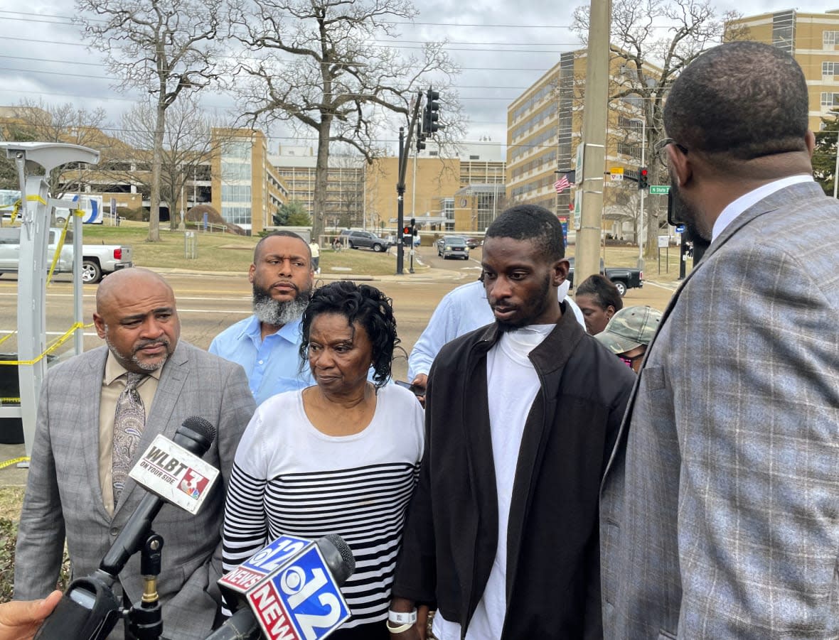 Michael Jenkins, second from right, stand with his mother, Mary Jenkins, center, and their attorneys at a news conference on Feb. 15. 2023, in Jackson, Miss., following his release from the hospital three weeks after being shot by sheriff’s deputies. (AP Photo/Michael Goldberg, File)