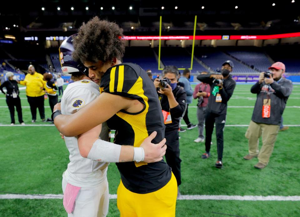 DeWitt quarterback Tyler Holtz, left, and Detroit King quarterback Dante Moore talk and hug it out after King won the Michigan High School Athletic Association Division 3 final against DeWitt, 25-21, at Ford Field in Detroit on Saturday, Nov, 27, 2021.