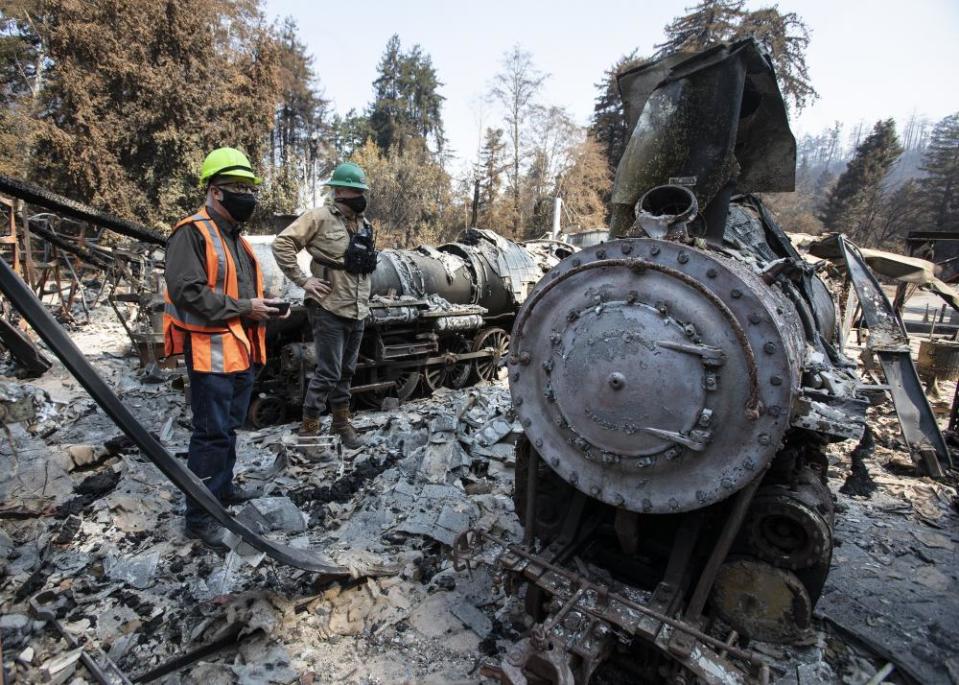 On 24 August, people survey the ruins of the Swanton Pacific Railroad roundhouse near Davenport, California, after it was destroyed in the CZU Lightning Complex fire.