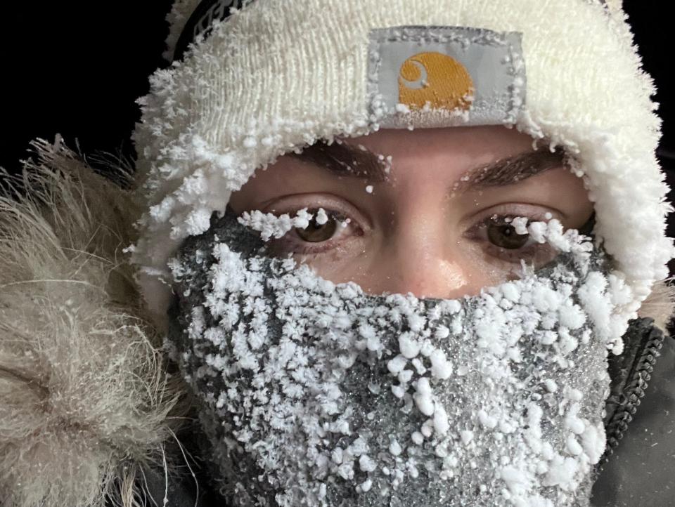 Selfie of the writer in a parka and scarf with snow covering her eyelashes and scarf