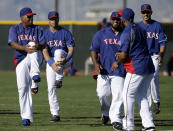 Texas Rangers' Adrian Beltre, left, Seattle Seahawks quarterback Russell Wilson, second from left, Rangers' Prince Fielder, center rear, Elvis Andrus, right front and Alex Rios, right rear, stretch before a morning work out during spring training baseball practice, Monday, March 3, 2014, in Surprise, Ariz. (AP Photo/Tony Gutierrez)