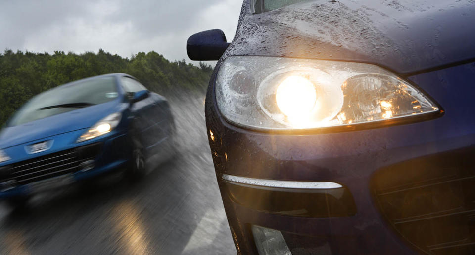 Two cars driving with headlights on. Source: Getty Images