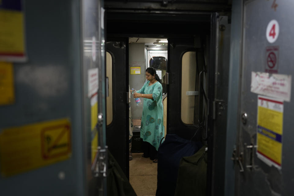 A passenger brushes her teeth in the morning on board the Thirukkural Express, India, Sunday, April 21, 2024. (AP Photo/Manish Swarup)