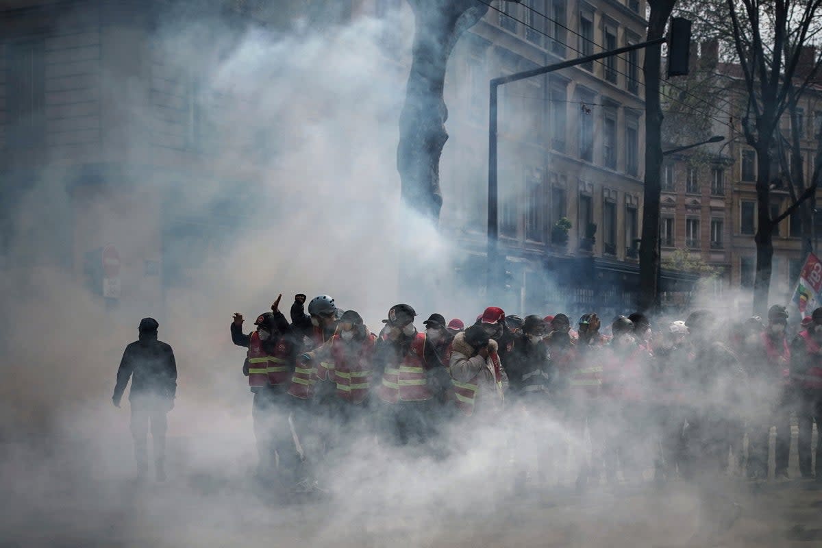 Union members stand in tear gas in Lyon on Thursday (AP)