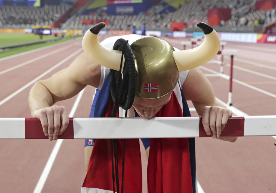 Karsten Warholm, of Norway, kisses a hurdle after he won the gold medal in the men's 400 meter hurdles final at the World Athletics Championships in Doha, Qatar, Monday, Sept. 30, 2019. (AP Photo/Hassan Ammar)