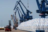 FILE PHOTO: A worker drives a forklift past sacks of polyester-making chemicals, waiting to be shipped, at Hengli Petrochemical's new refining, petrochemical complex at Changxing island in Dalian