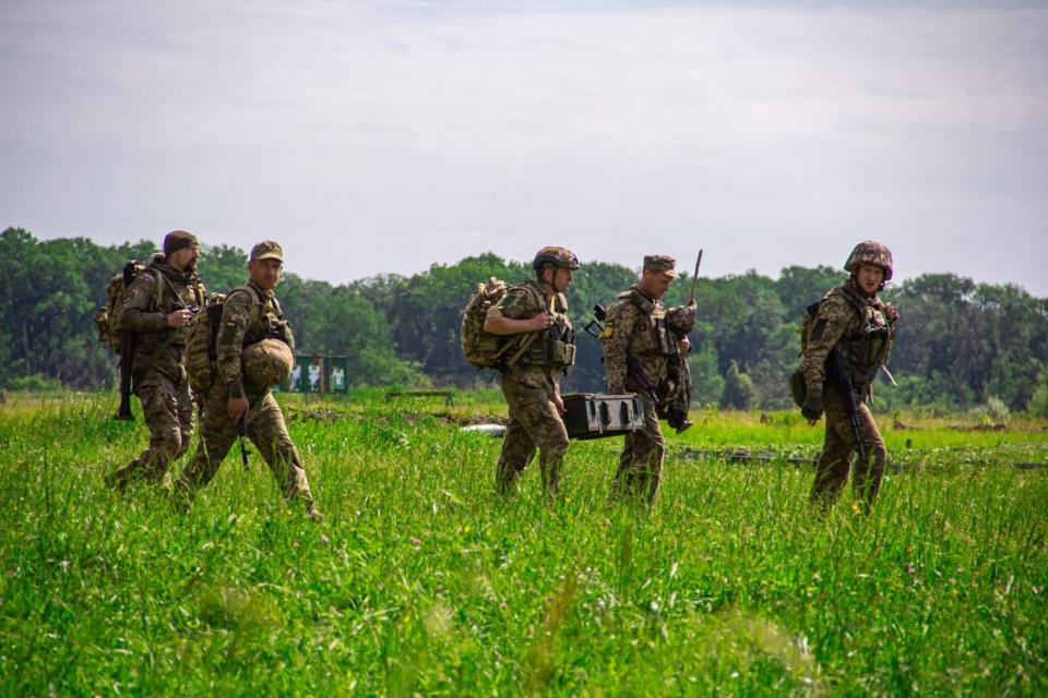 Soldiers with the 32nd Mechanized Brigade cross a field in May. (Oleksandr Bordian / Courtesy)
