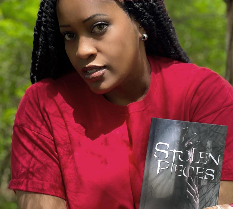 Ambridge author J.R. Mason holds her new novel, "Stolen Pieces."