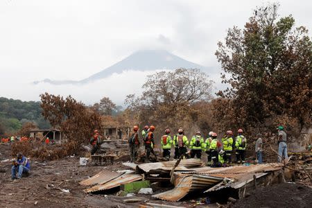 Rescue workers search the house of one of Eufemia Garcia's missing sisters in an area affected by the Fuego volcano at San Miguel Los Lotes in Escuintla, Guatemala, June 15, 2018. REUTERS/Carlos Jasso