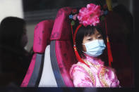 A girl wears a mask inside a bus in Hong Kong, Saturday, Jan. 25, 2020. China's most festive holiday began in the shadow of a worrying new virus Saturday as the death toll surpassed 40, an unprecedented lockdown kept 36 million people from traveling and authorities canceled a host of Lunar New Year events. (AP Photo/Achmad Ibrahim)