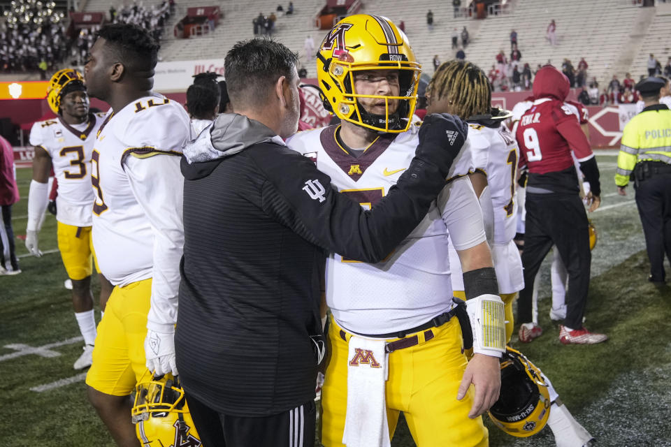 Minnesota quarterback Tanner Morgan, front right, is hugged by a member of the Indiana staff after an NCAA college football game against Indiana in Bloomington, Ind., Saturday, Nov. 20, 2021. (AP Photo/AJ Mast)