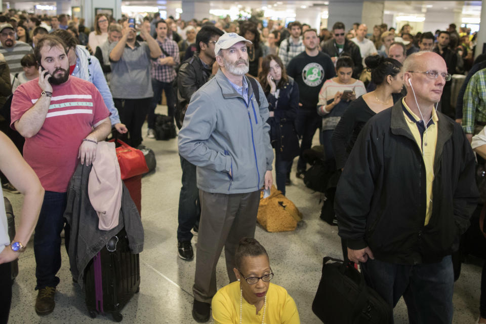 Evening rush hour commuters look at the departures board while at Penn Station, Friday, April 14, 2017, in New York. A New Jersey Transit train with about 1,200 passengers aboard is stuck in a Hudson River tunnel between New York and New Jersey. Authorities say the Northeast Corridor train became disabled Friday due to an Amtrak overhead power problem. (AP Photo/Mary Altaffer)