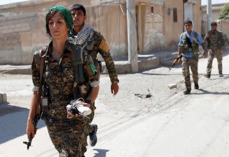 Sheen Ibrahim, Kurdish fighter from the People's Protection Units (YPG) walks together with other YPG fighters in Raqqa, Syria June 16, 2017. REUTERS/Goran Tomasevic