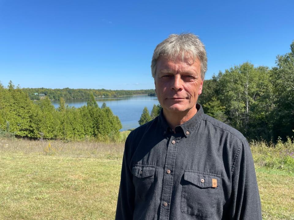Tim Schruder, who lives right next to the site of the proposed gravel pit, stands in front of Barber's Lake. 