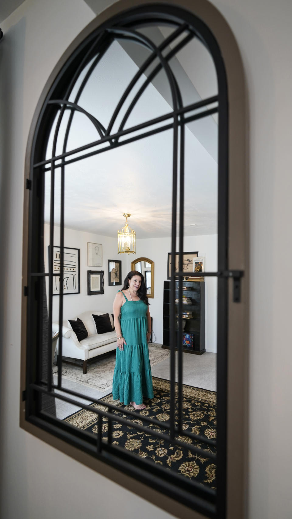 Heather Bise, owner of The House of Bise Bespoke, is reflected in a mirror in the "Art" bedroom, Monday, July 19, 2021, in Cleveland. Small businesses in the U.S. that depend on tourism and vacationers say business is bouncing back, as people re-book postponed trips and take advantage of loosening restrictions, a positive sign for the businesses that have struggled for more than a year. Bise started in 2019 and catered to international tourists, attracting guests from New Zealand, Botswana, Eastern Europe and elsewhere. (AP Photo/Tony Dejak)