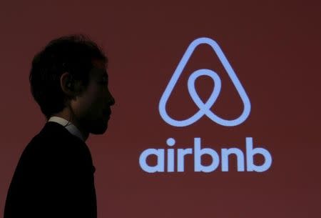 A man walks past a logo of Airbnb after a news conference in Tokyo, Japan, November 26, 2015. REUTERS/Yuya Shino