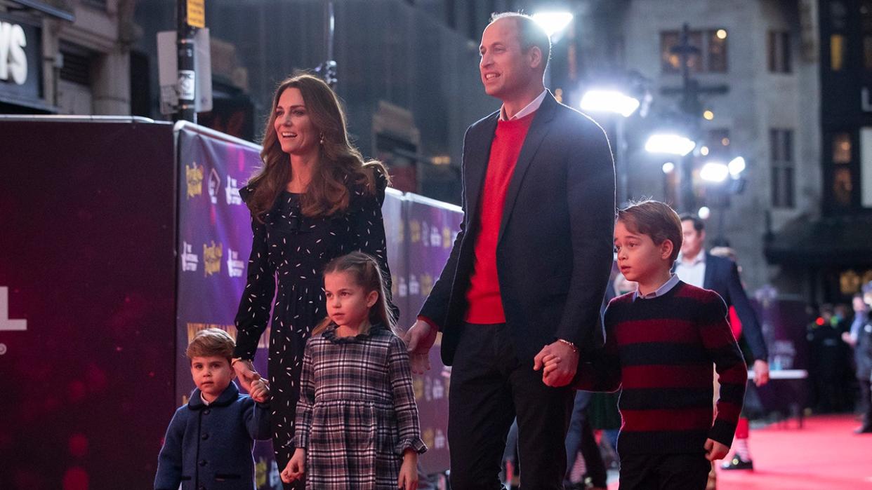 Kate Middleton and Prince William holding the hands of their three children