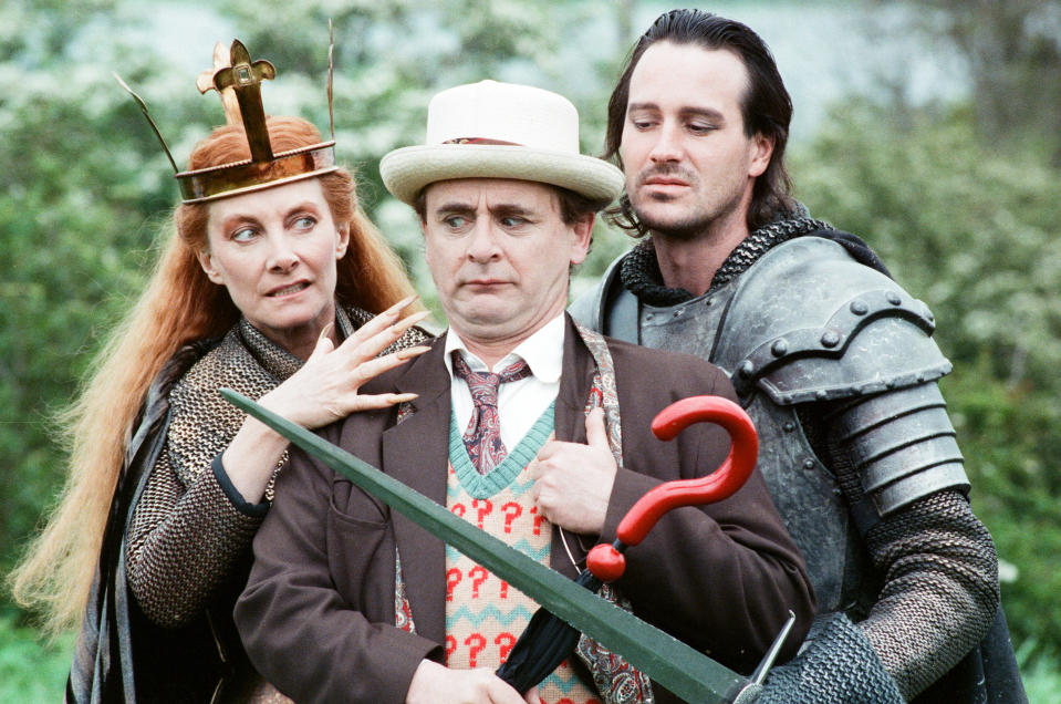 Christopher Bowen as Mordred crosses swords with Sylvester McCoy as the Doctor along with Jean Marsh as Morgaine whilst on location filming for the Dr Who story Battlefield, 16th May 1989. (Photo by Arnold Slater/Mirrorpix/Getty Images)