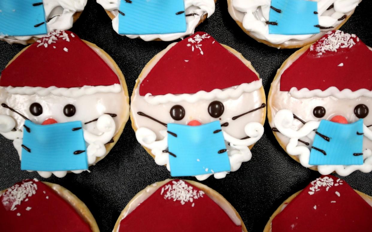 Christmas biscuits depicting Father Christmas wearing a face mask -  FRIEDEMANN VOGEL//EPA-EFE/Shutterstock