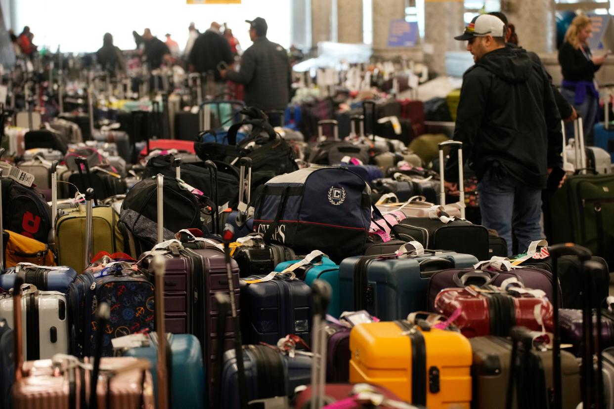 Travelers wade through fields of unclaimed luggage by the baggage casrousels for Southwest Airlines in Denver International Airport, Tuesday, Dec. 27, 2022, in Denver.