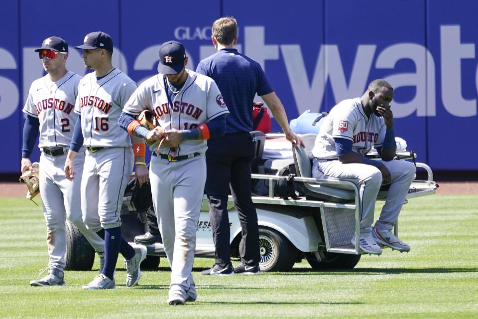 Houston Astros' Yordan Alvarez, right, is take off the field on a cart after he was injured colliding with Jeremy Pena trying to catch a fly ball by New York Mets' Dominic Smith during the eighth inning of a baseball game, Wednesday, June 29, 2022, in New York. (AP Photo/Mary Altaffer)