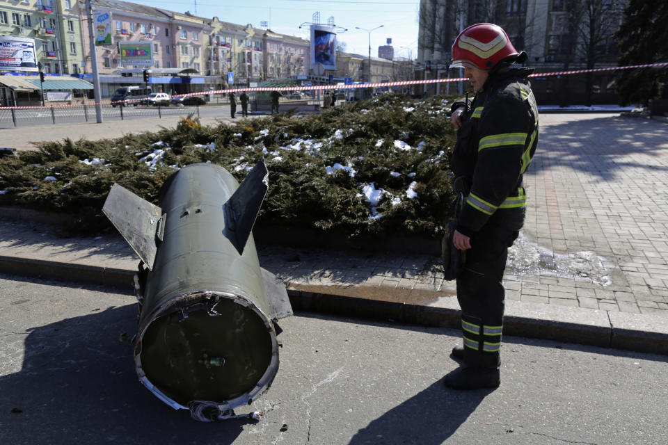 A firefighter looks at a fragment of a Ukrainian Tochka-U missile on a street in Donetsk in eastern Ukraine, Monday, March 14, 2022. The Russian military says that at least 20 civilians have been killed by a ballistic missile launched by the Ukrainian forces. (AP Photo/Alexei Alexandrov)
