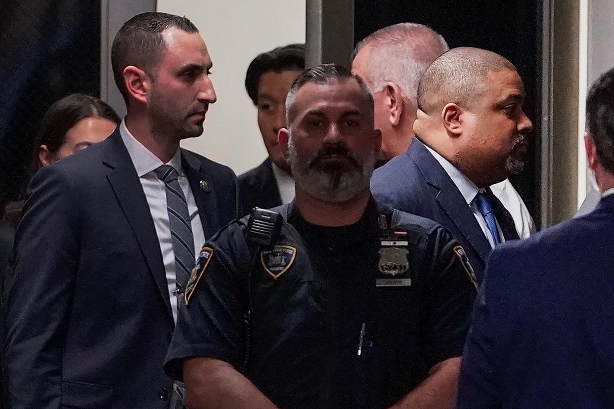 Manhattan District Attorney Alvin Bragg, far right, passes through a hallway outside the courtroom Tuesday in New York.