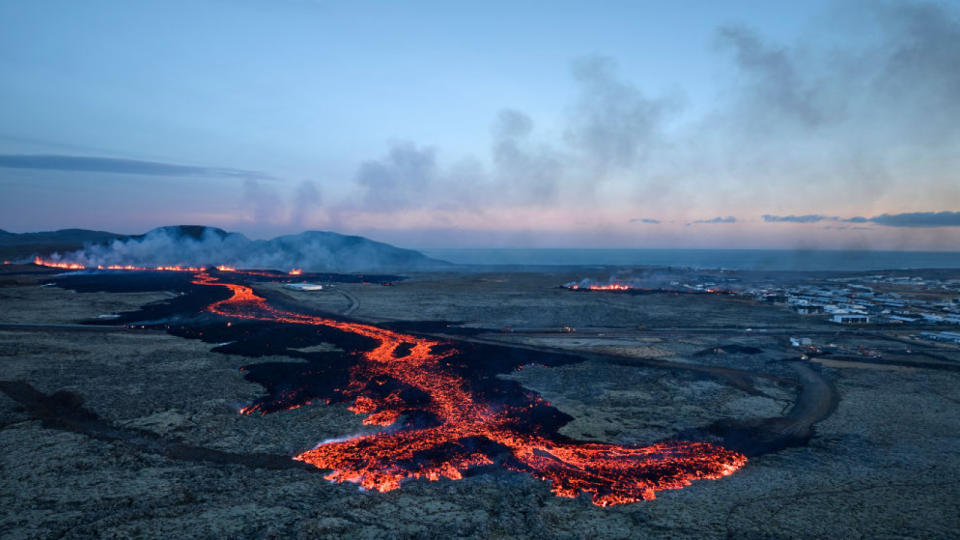 Lava explosions and billowing smoke are seen near residential buildings in the southwestern Icelandic town of Grindavik after a volcanic eruption on January 14, 2024.